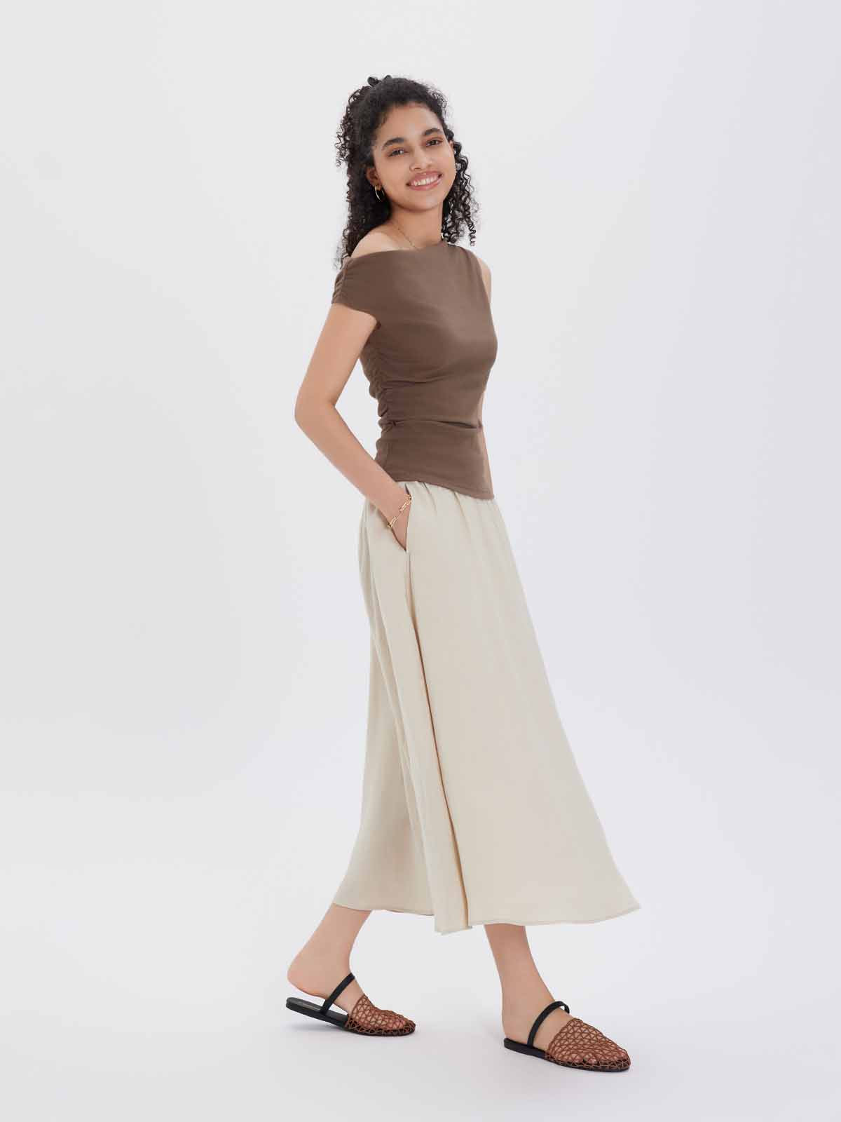 Woman wearing a brown top and beige skirt